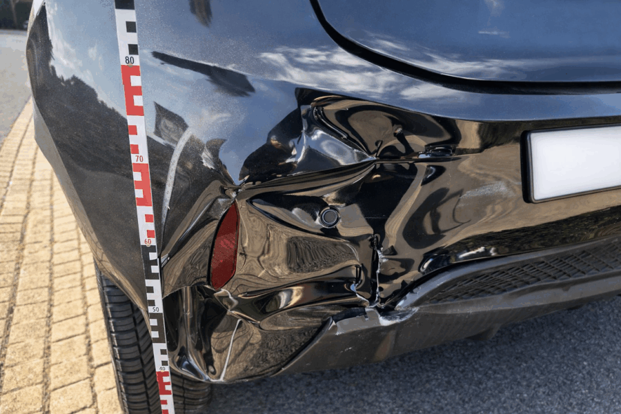 Heckschaden an einem nahezu neuen Fahrzeug mit Messlatte zur Schadendokumentation nach einem Verkehrsunfall